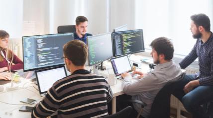 Team di sviluppo al lavoro davanti ai monitor